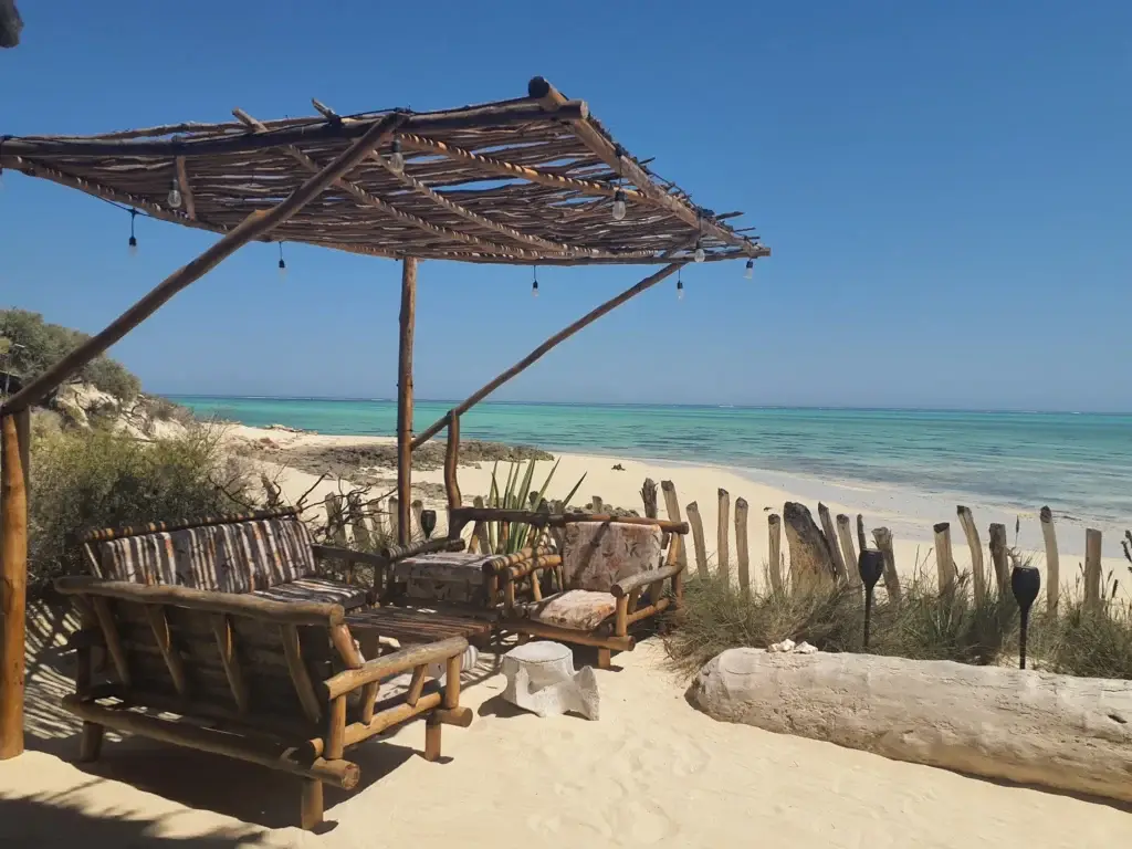 Salon en bois sous une pergola face à la plage d'Ambatomilo